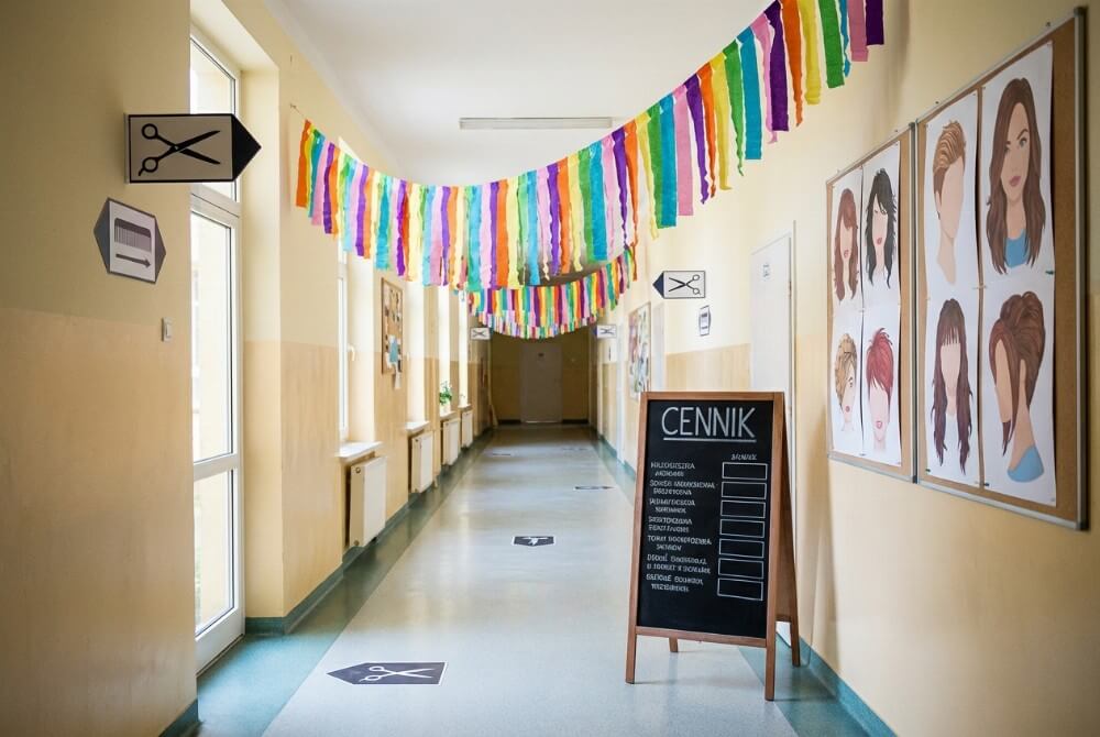 Dekoracje szkolnego korytarza w stylu salonu fryzjerskiego z krepiną i piktogramami akcesoriów